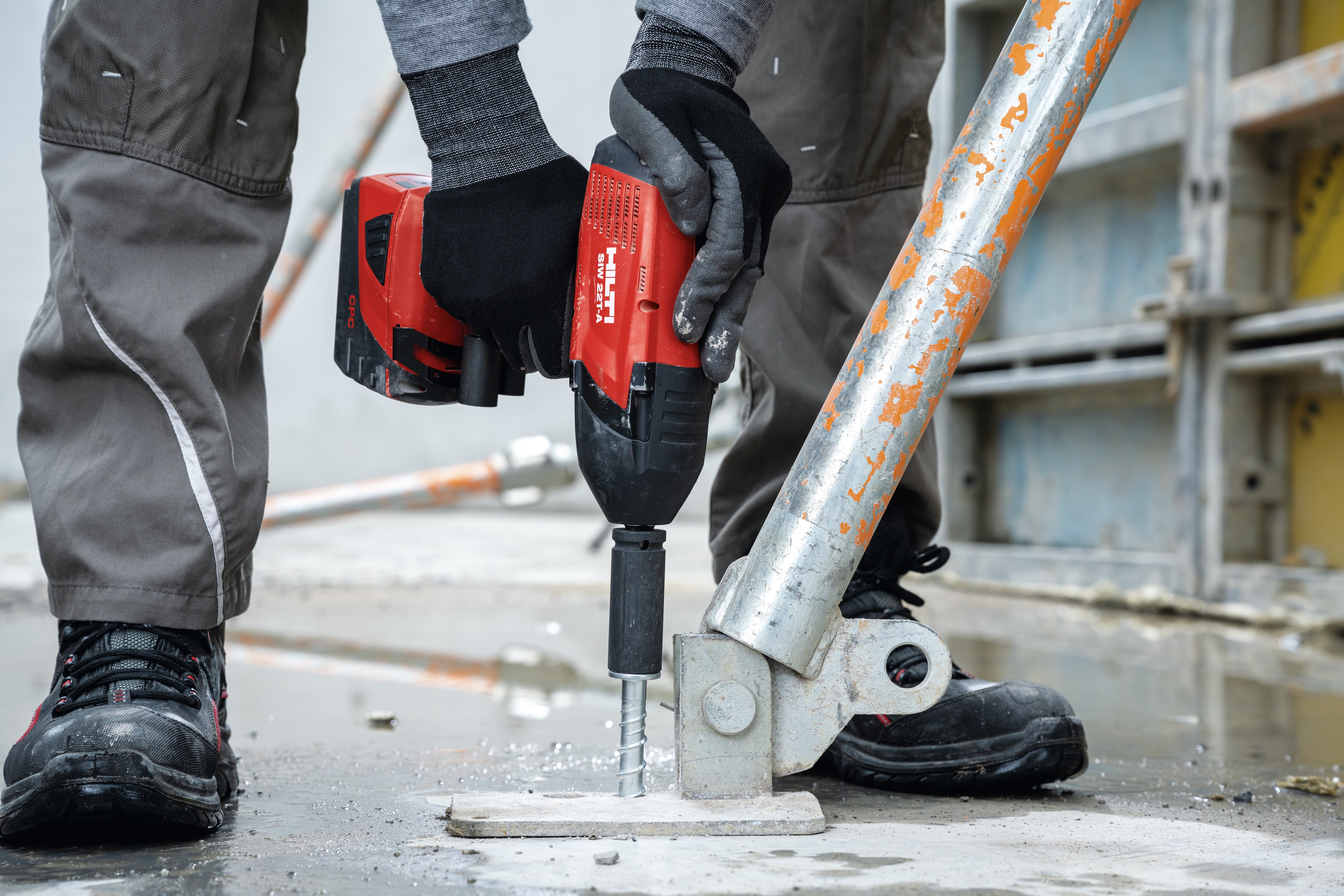 A worker attaches a formwork support with a concrete screw