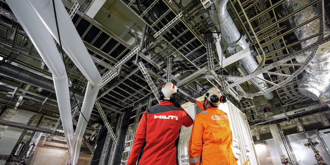 ein Hilti Mitarbeiter und ein Kunde betrachten eine korrosionsbeständige Installation