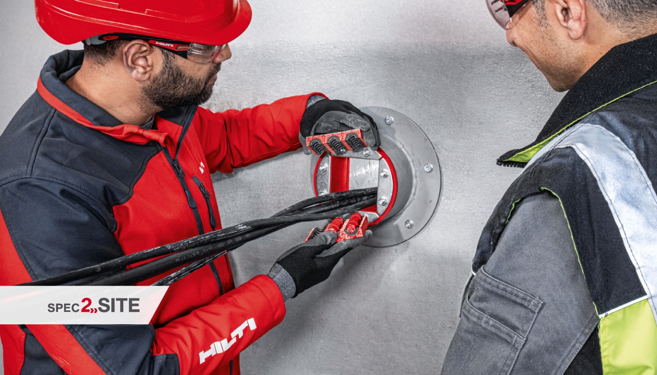 Hilti-Ingenieur demonstriert einem Kunden eine Brandschutzhülse für eine Elektroanwendung