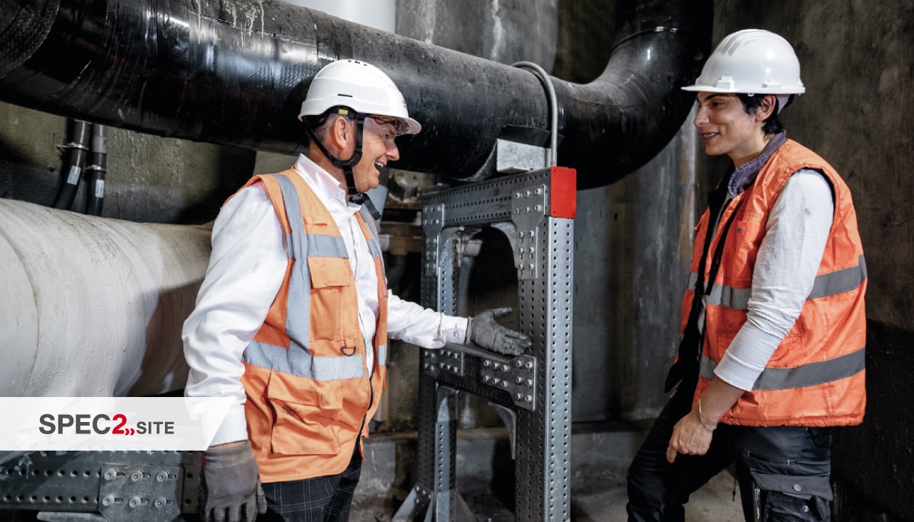 Ein Ingenieur von Hilti und ein Kunde begutachten ein modulares Installationssystem für Rohrleitungen.