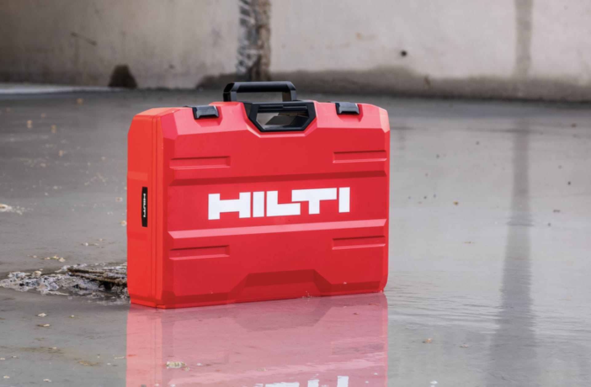 Bild teilt sich in zwei Bereiche: Links hebt ein Mann einen roten Hilti Koffer aus dem Regal, recht sind Illustrationen von drei Geräten in Graustufen zu sehen, davor ein roter Kreis mit einem weißen Euro-Zeichen in der Mitte.  