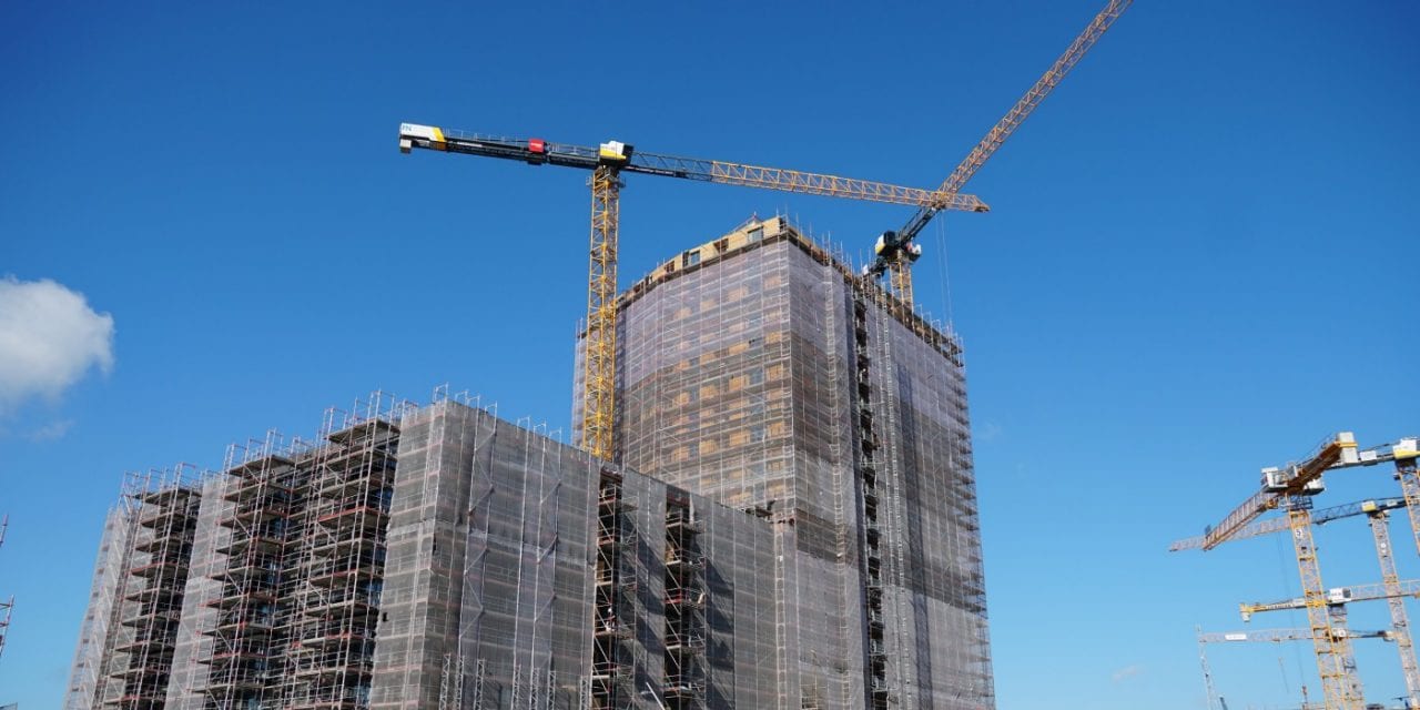 Das Gebäude des “Roots” Hochhaus während des Baus, im Hintergrund blauer Himmel.