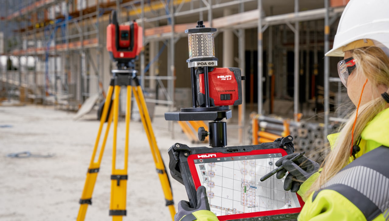 Eine Frau bedient Hilti Messtechnik auf einer Baustelle.