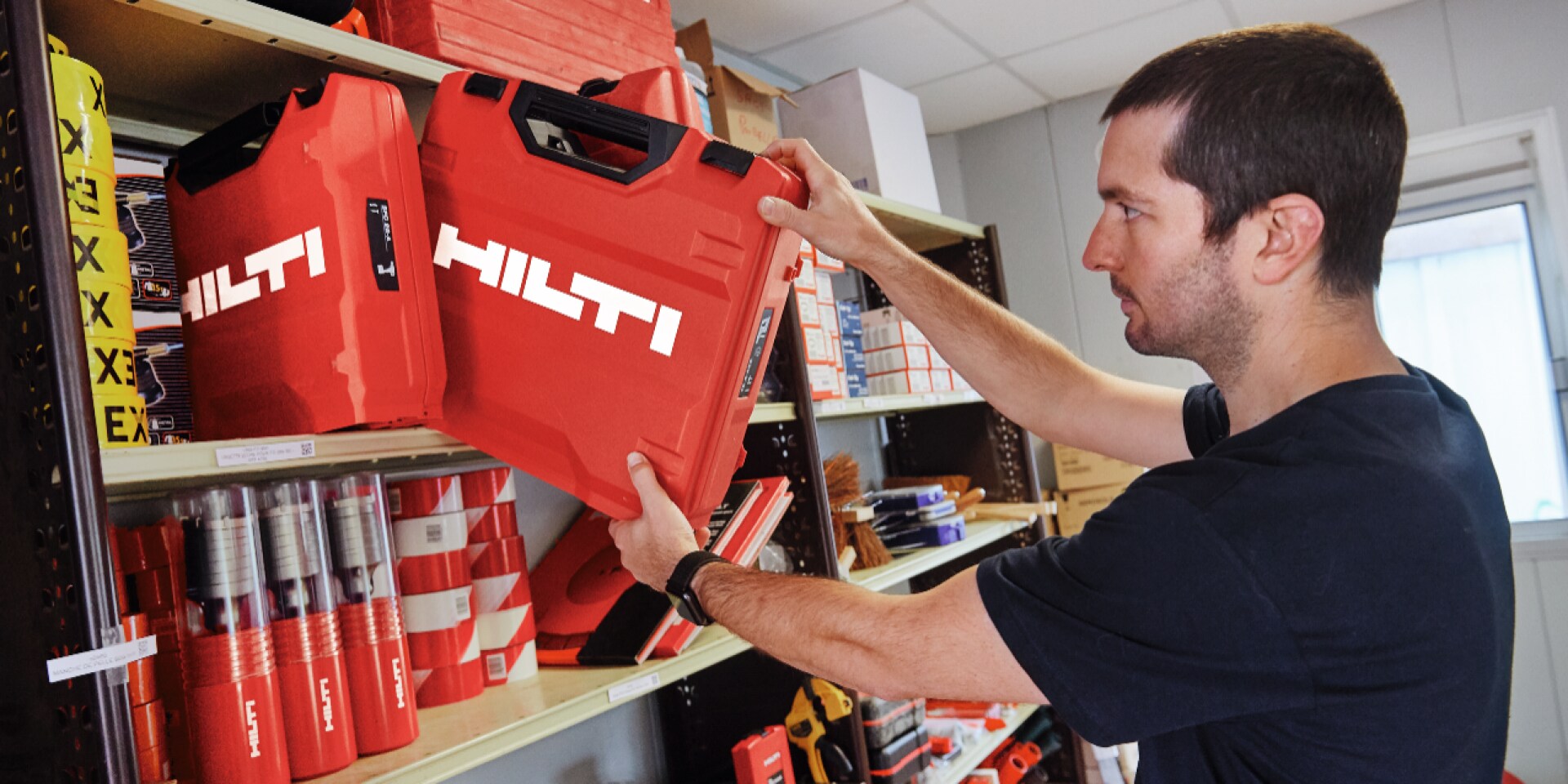 Eine Person schiebt einen Hilti Koffer in ein Regal.